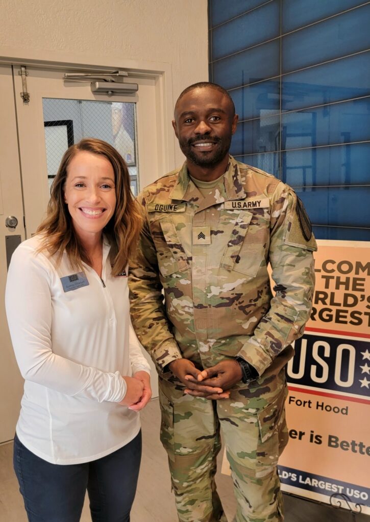 A woman standing next to a man in an army uniform