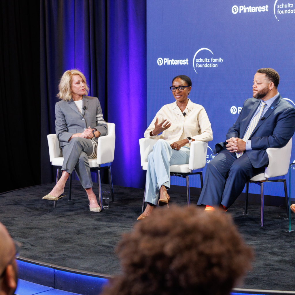 Three people sitting on a stage.